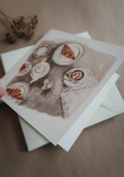 Coffee table with croissants, folded card